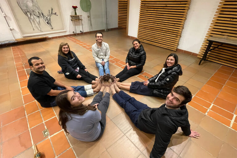 Participantes recostados en círculo en el piso de un salón