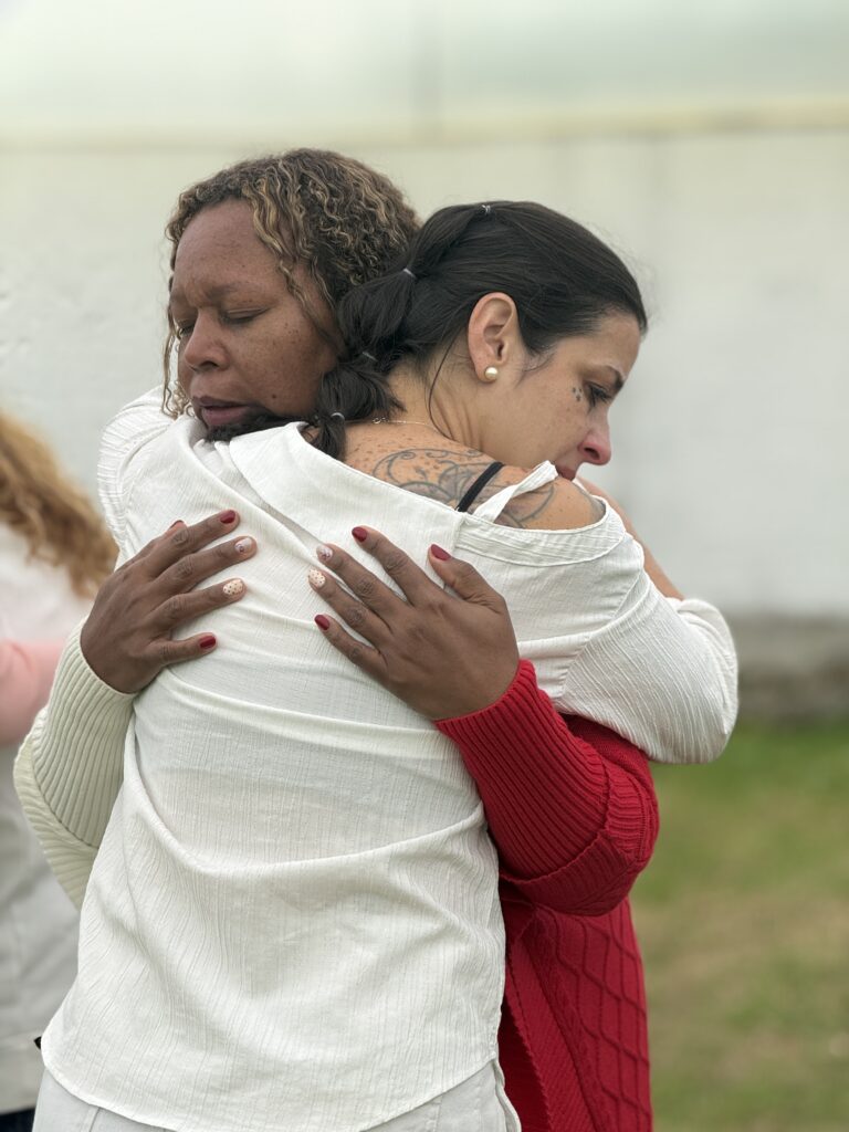 Dos participantes se abrazan al cierre de un encuentro en Casa Tibaná, Chía