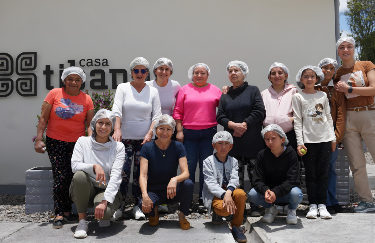 Participantes de una actividad de cocina frente al letrero de Casa Tibaná